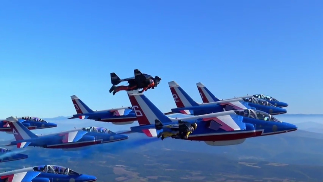 Vea hombres con jetpacks volar en formación con aviones